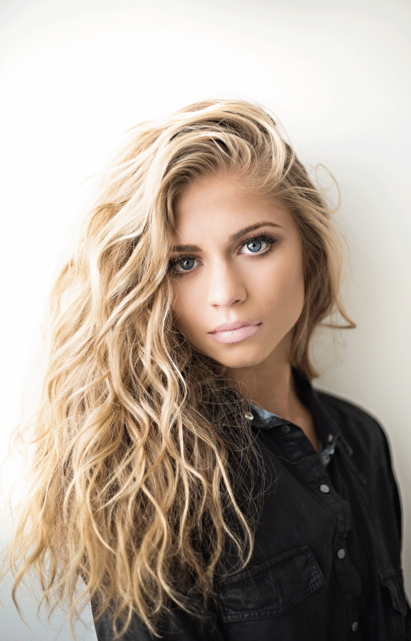 "she has green eyes and wavy blonde hair "是什么意思?