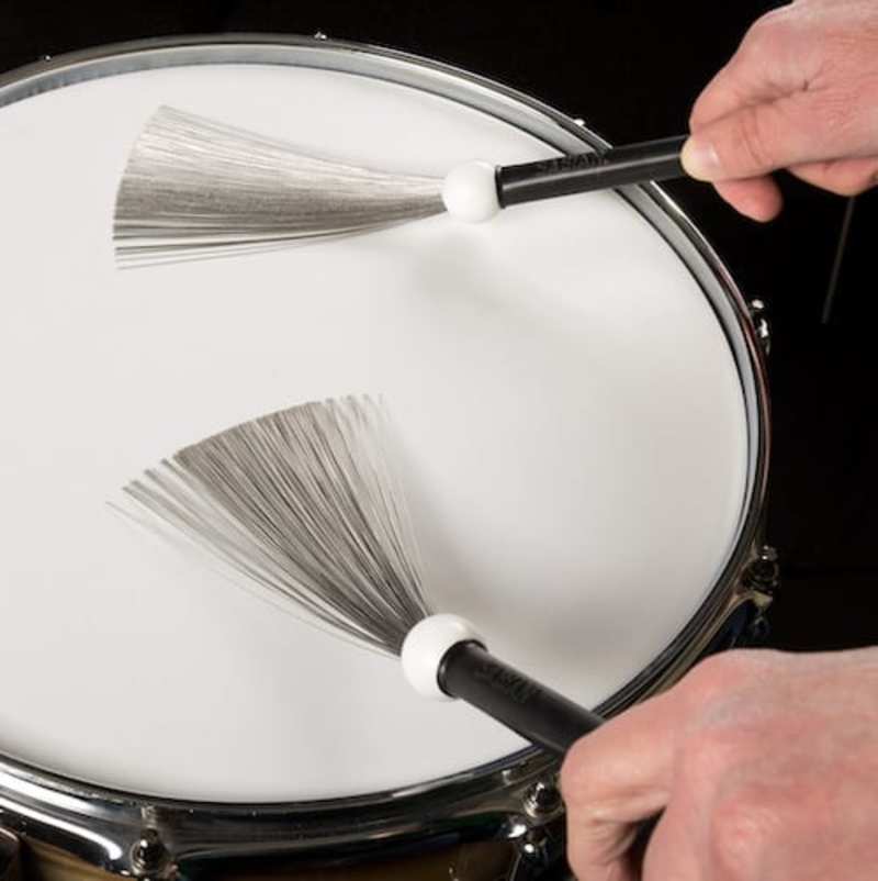 What is the meaning of "He lays down a groove with brushes and