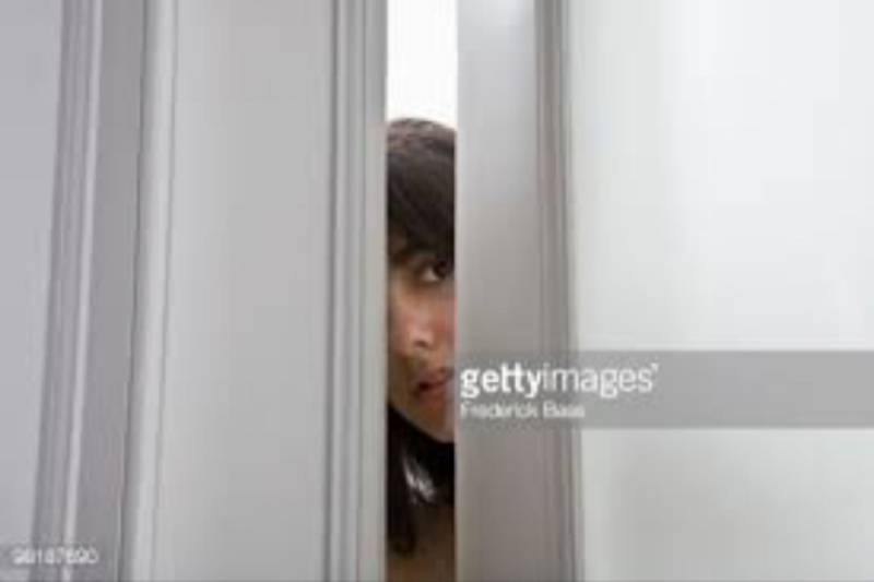 What Is This Woman Doing Looking Through A Partially Opened